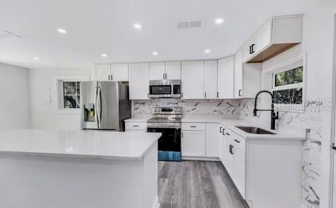 1353 Chatauqua Way Keystone Heights, FL 32656 - Photo 47 of 60 a kitchen with stainless steel appliances granite countertop a sink stove refrigerator and cabinets