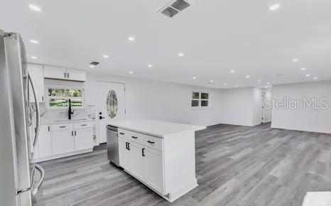 1353 Chatauqua Way Keystone Heights, FL 32656 - Photo 48 of 60 a view of a kitchen with kitchen island white cabinets and wooden floor