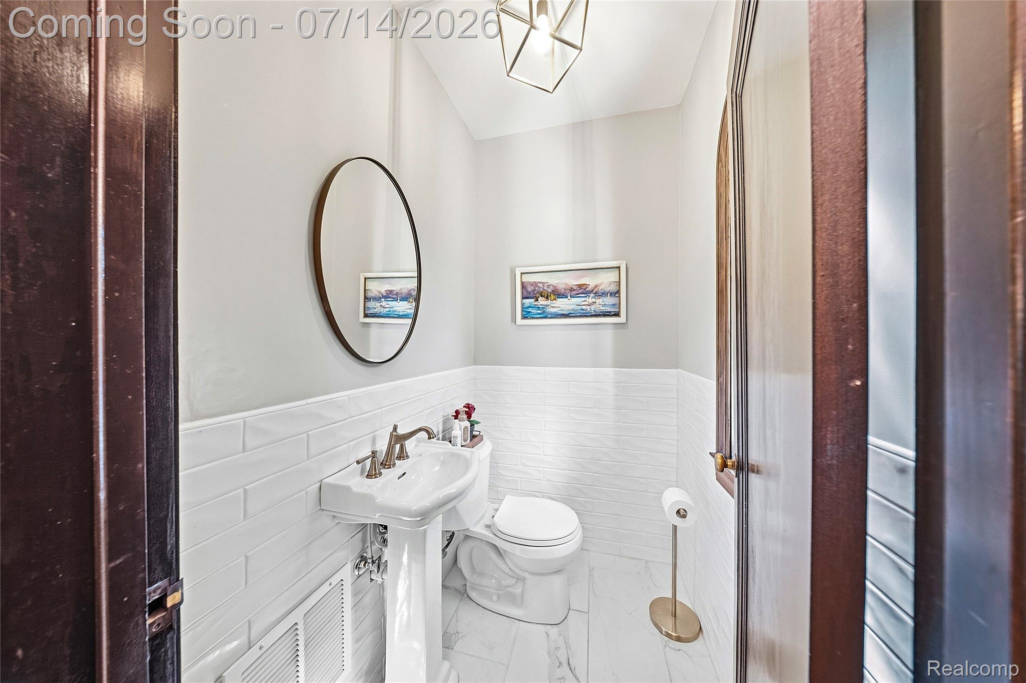 18460 Meridian Road Grosse Ile, MI 48138 - Photo 24 of 50 Powder room featuring a pedestal sink with a brushed nickel faucet, white subway tile wainscoting, and marble-look floor tiling