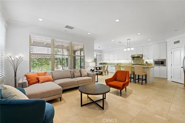 a living room with furniture kitchen and a large window