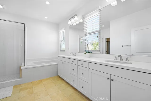 a spacious bathroom with a tub sink and mirror