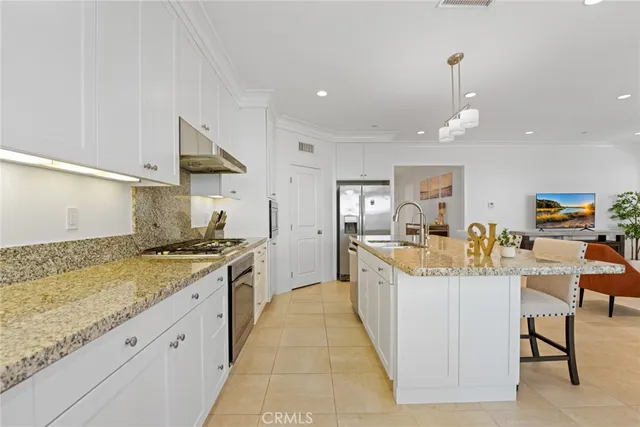 a large kitchen with stainless steel appliances kitchen island granite countertop a sink and cabinets