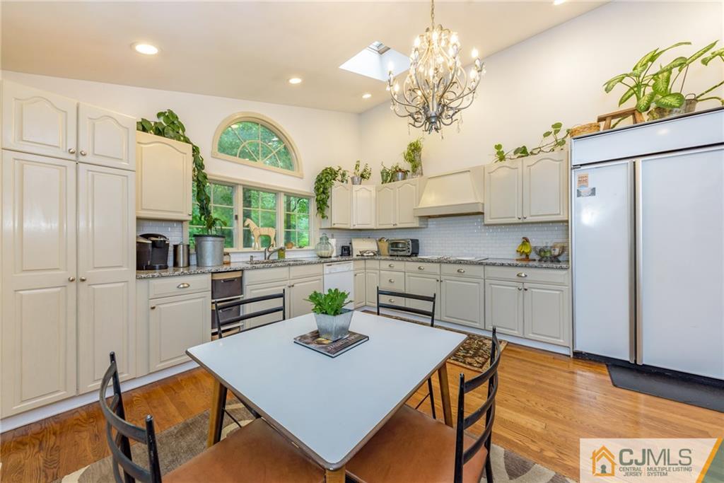 7 Bradford Road Edison, NJ 08820 - Photo 13 of 34 a kitchen with a refrigerator a stove a sink dishwasher and white cabinets with wooden floor