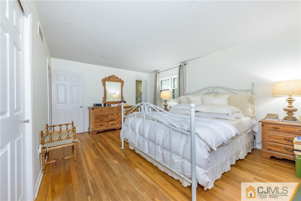 7 Bradford Road Edison, NJ 08820 - Photo 17 of 34 a spacious bedroom with a bed and a flat tv screen on dresser