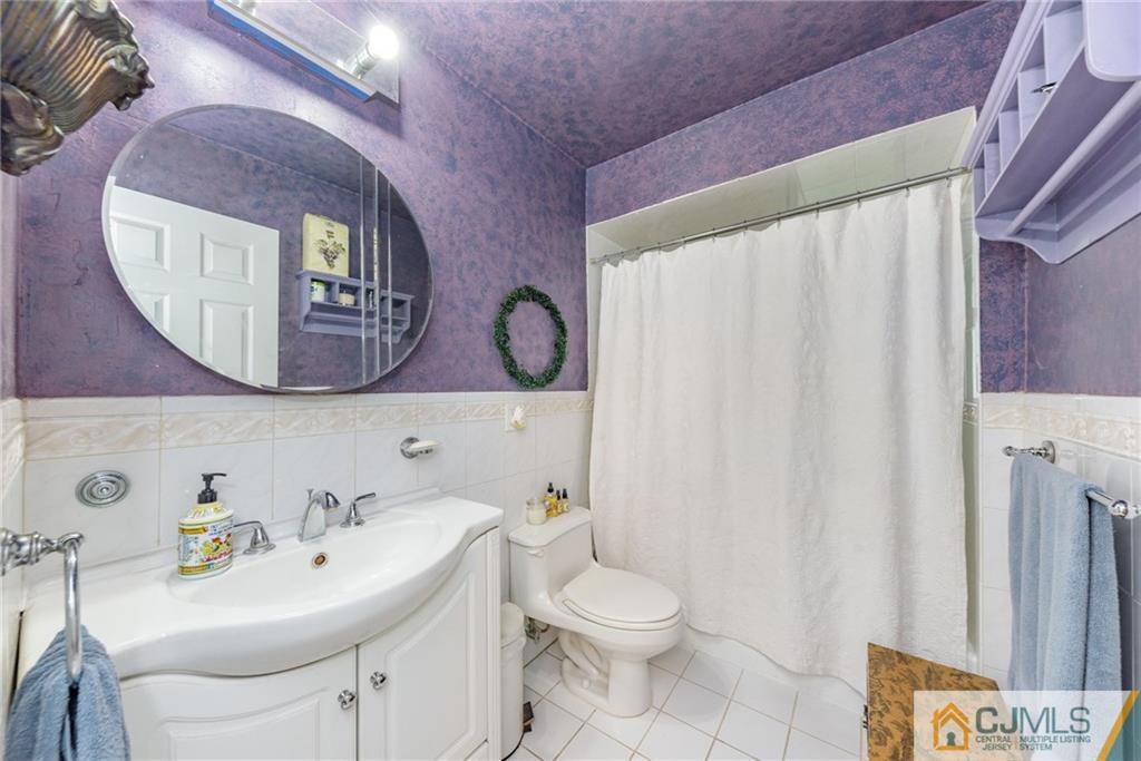 7 Bradford Road Edison, NJ 08820 - Photo 23 of 34 a bathroom with a sink and mirror with toilet