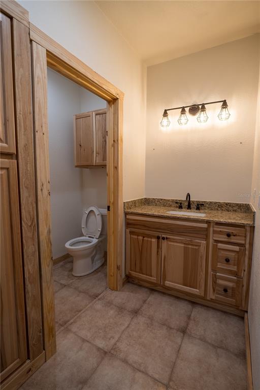 2051 Southeast 155th Street Summerfield, FL 34491 - Photo 34 of 48 a bathroom with a granite countertop sink a toilet and a mirror