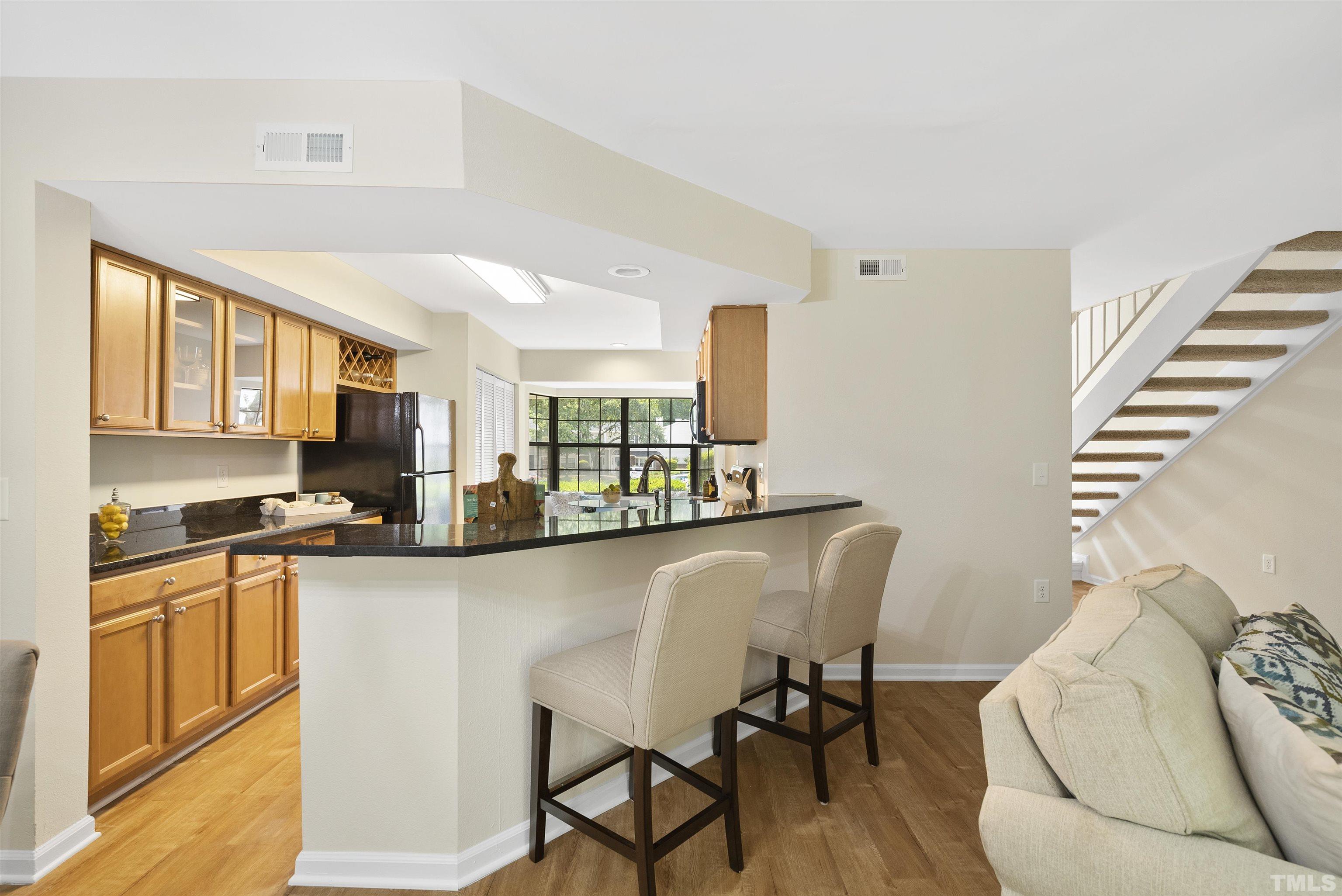 7779 Falcon Rest Circle Raleigh, NC 27615 - Photo 12 of 28 a kitchen with stainless steel appliances granite countertop a microwave a stove and white cabinets
