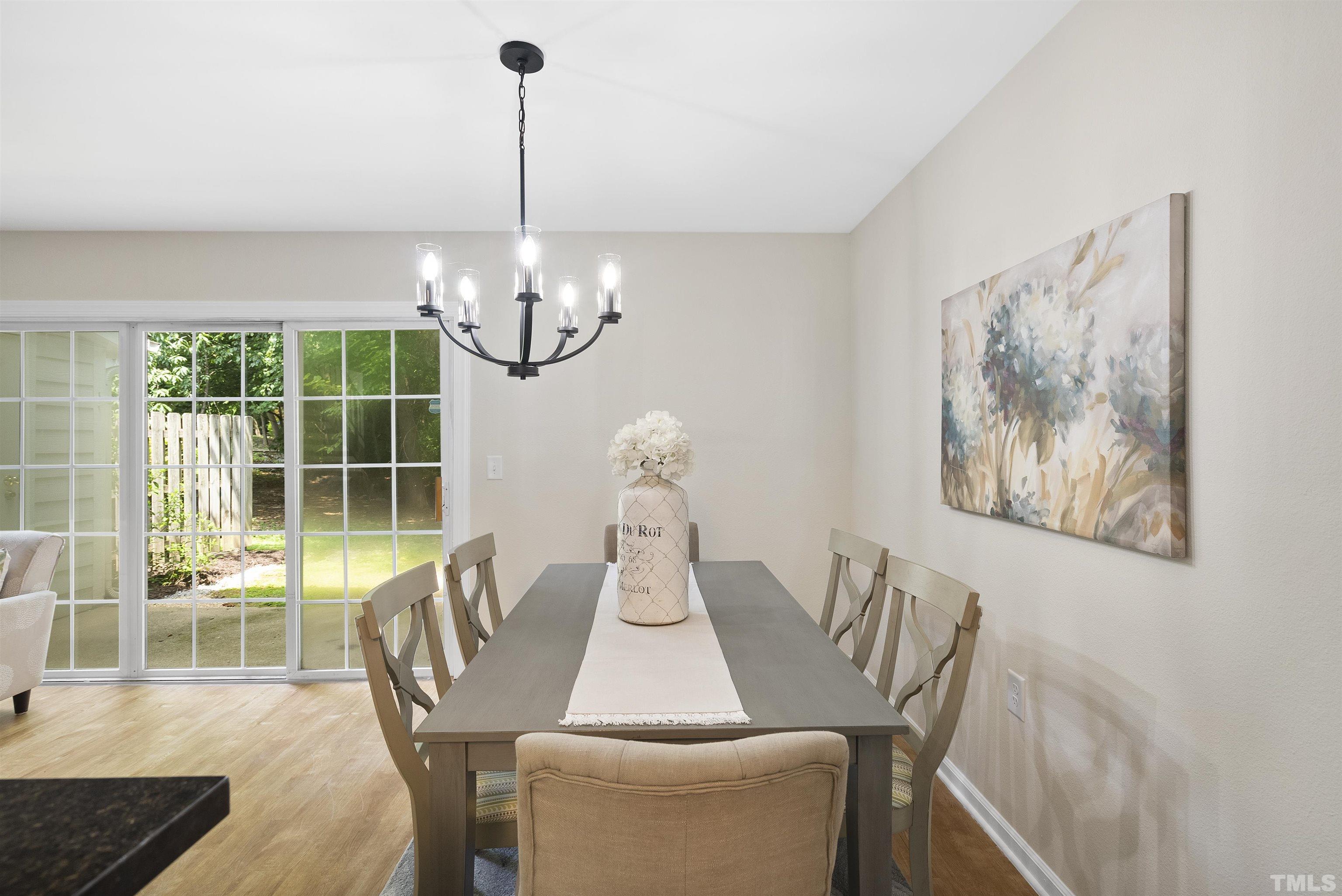 7779 Falcon Rest Circle Raleigh, NC 27615 - Photo 13 of 28 a dining room with furniture a chandelier and wooden floor