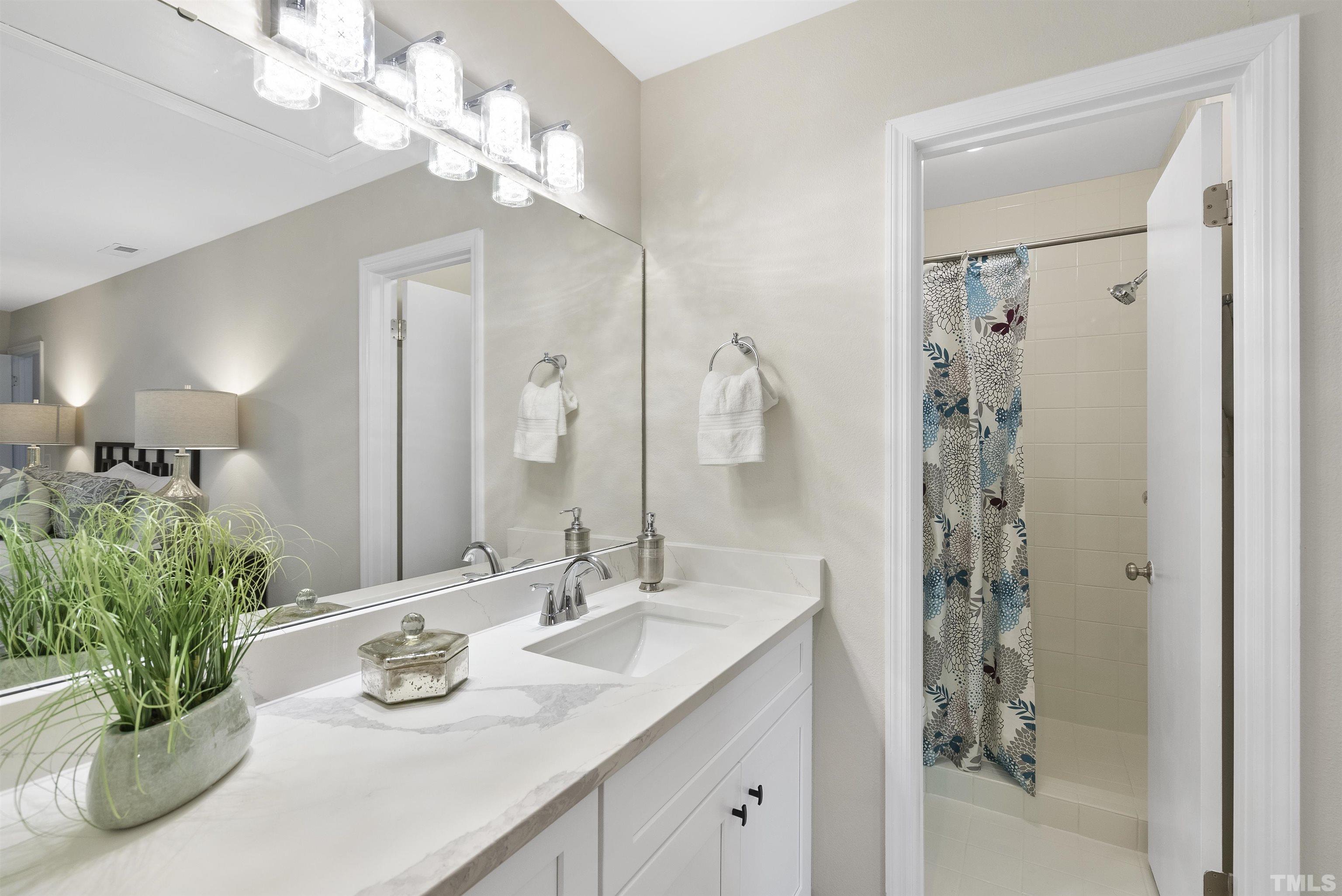 7779 Falcon Rest Circle Raleigh, NC 27615 - Photo 23 of 28 a bathroom with a sink a vanity and a mirror