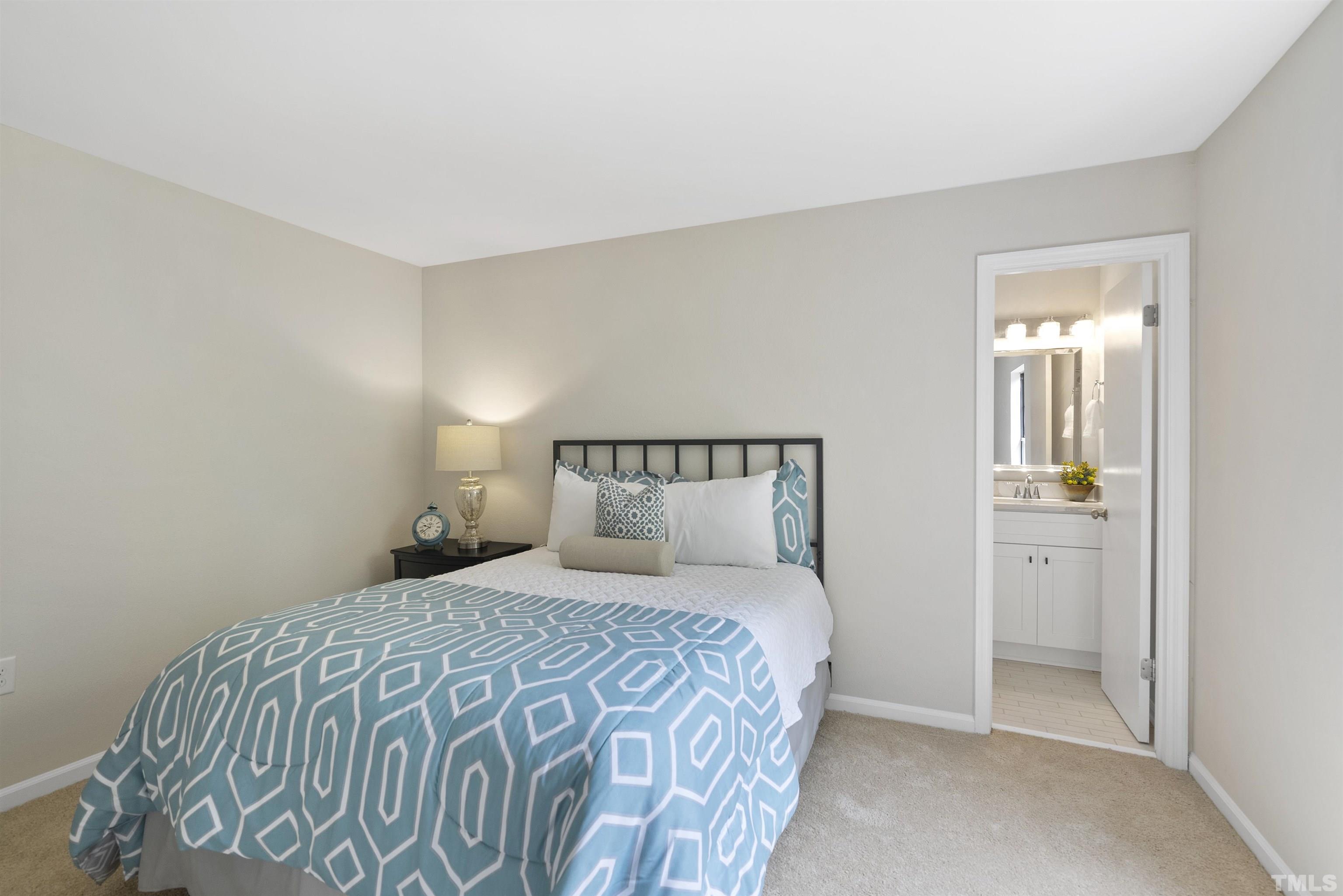 7779 Falcon Rest Circle Raleigh, NC 27615 - Photo 25 of 28 a bedroom with a bed and a mirror