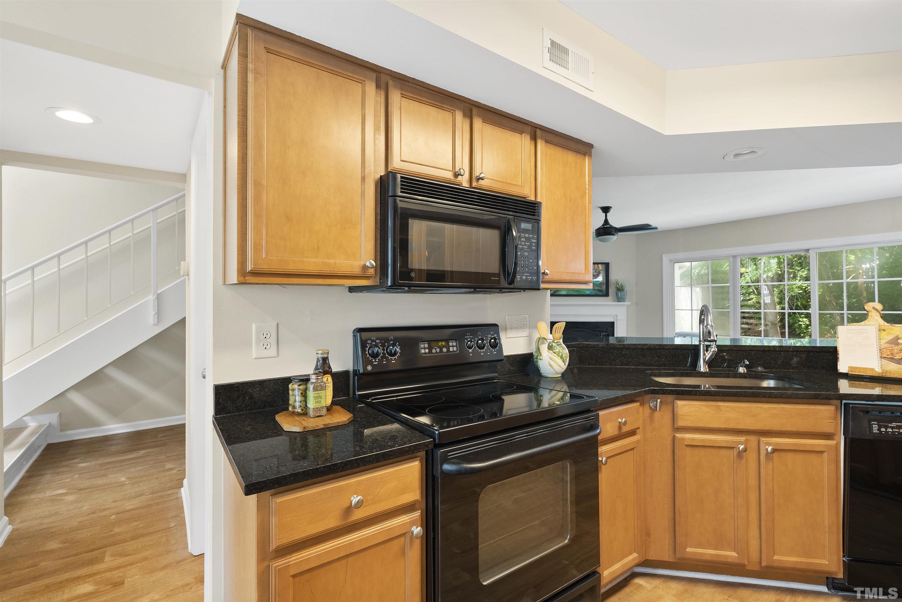 7779 Falcon Rest Circle Raleigh, NC 27615 - Photo 9 of 28 a kitchen with granite countertop a stove sink and microwave