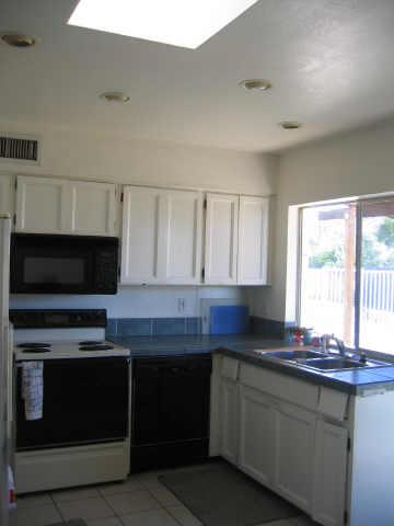 4019 East St John Road Phoenix, AZ 85032 - Photo 5 of 6 a kitchen with stainless steel appliances a stove microwave and sink