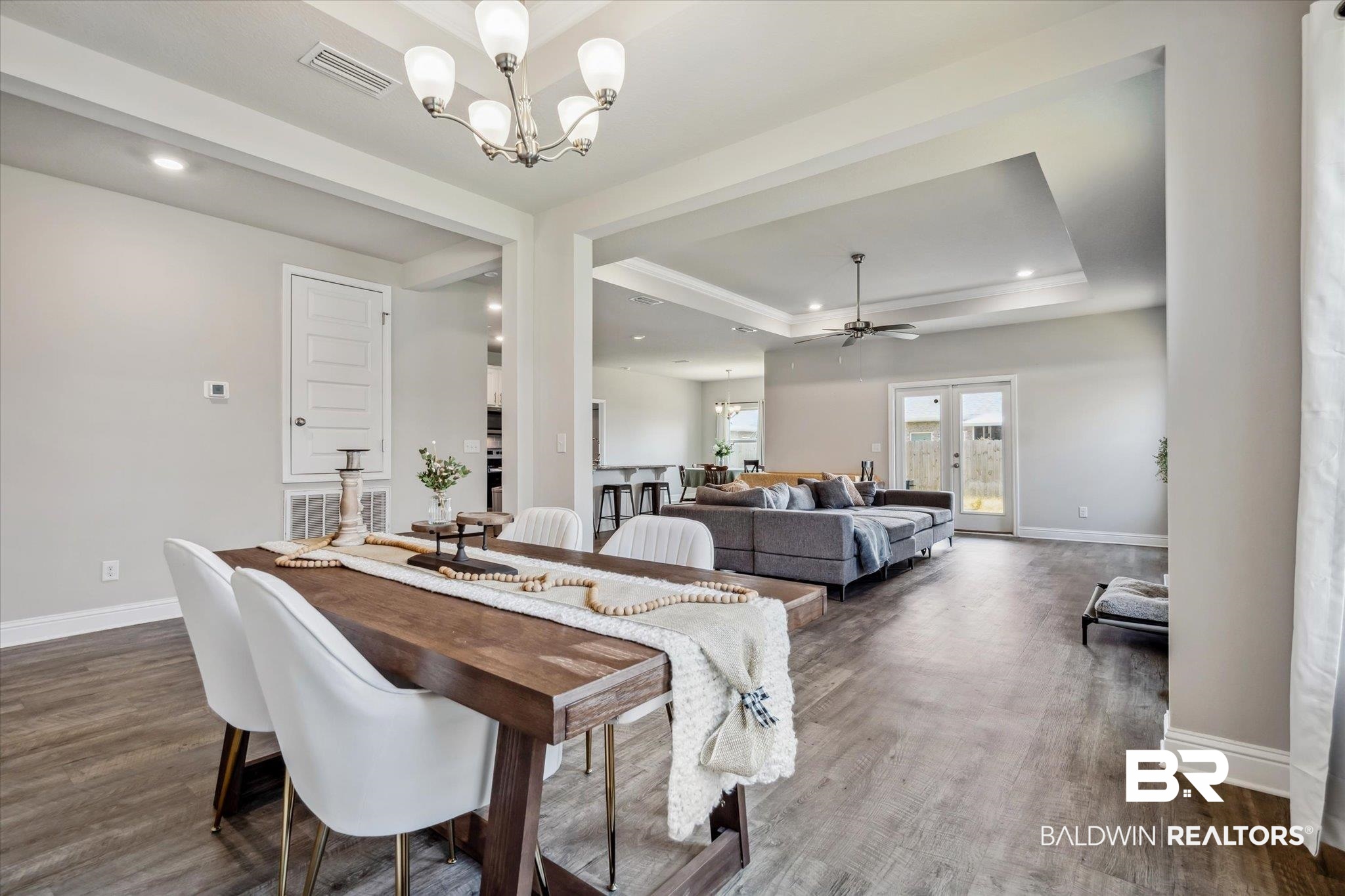 10501 Loamy Avenue Mobile, AL 36695 - Photo 4 of 30 Dining room with dark hardwood / wood-style floors, ceiling fan with notable chandelier, french doors, and a raised ceiling