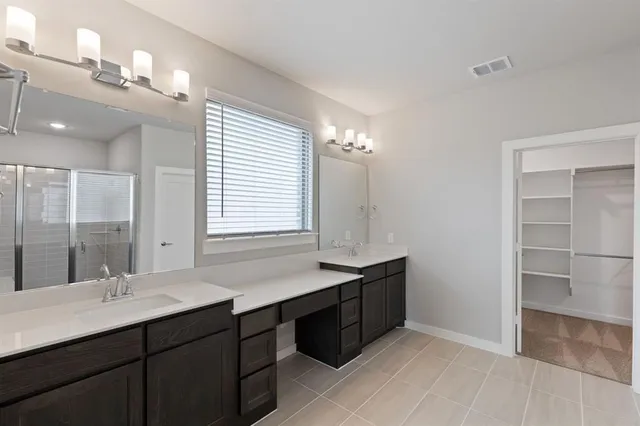 a bathroom with a double vanity sink a mirror and a bathtub