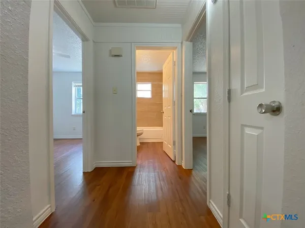 a view of an empty room with wooden floor