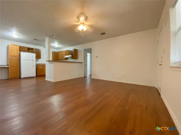 a view of a kitchen with a sink and a refrigerator