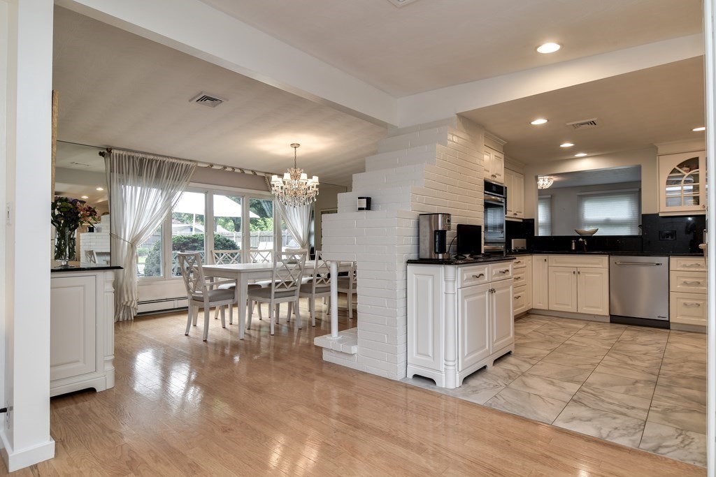 41 Lohnes Road Framingham, MA 01701 - Photo 5 of 36 a kitchen with stainless steel appliances kitchen island granite countertop a refrigerator a stove a sink a dining table and chairs with wooden floor