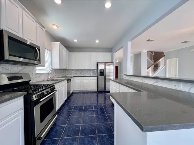 a kitchen with stainless steel appliances a refrigerator and microwave