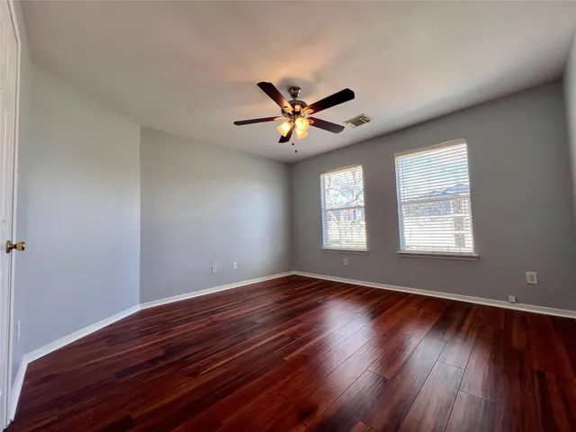 a view of room with hardwood floor and ceiling fan