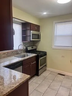 a kitchen with stainless steel appliances granite countertop a sink and a stove