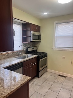 1329 East 89th Place Chicago, IL 60619 - Photo 4 of 11 a kitchen with stainless steel appliances granite countertop a sink and a stove