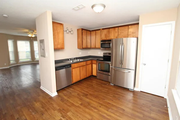 a kitchen with stainless steel appliances granite countertop a refrigerator a sink a stove and oven