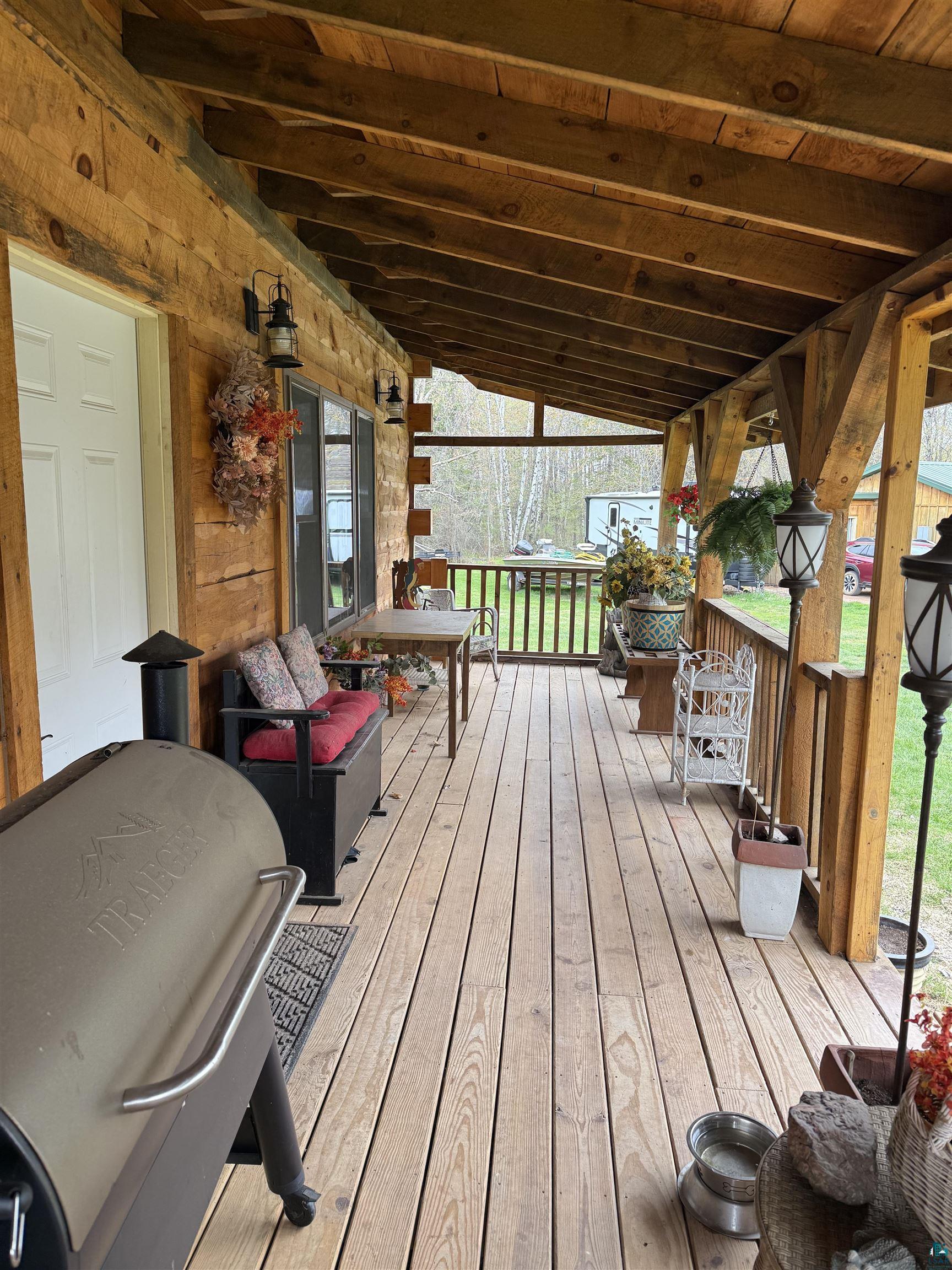 37590 Degerstrom Road Askov, MN 55704 - Photo 32 of 53 Expansive covered porch featuring wood-plank flooring, exposed wood beam ceiling, and log-style exterior siding