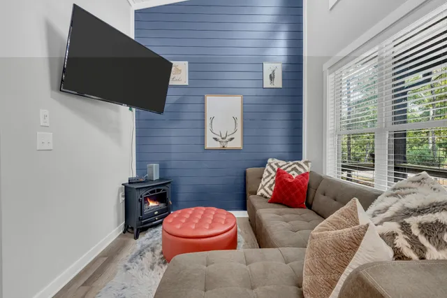 a living room with furniture and a dining table with wooden floor