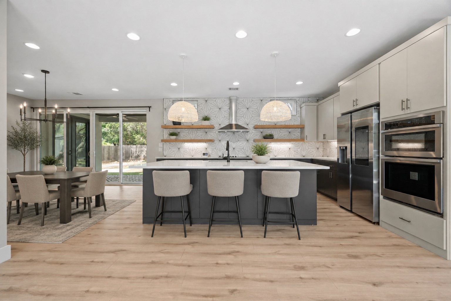 11506 Autumn Ridge Drive Austin, TX 78759 - Photo 3 of 23 A contemporary open-concept kitchen features a spacious island and seamlessly connects to the dining area and outdoor patio. Virtually staged.