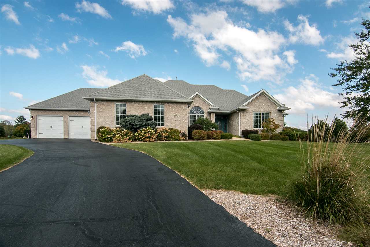 12210 Bellingham Road Caledonia, IL 61011 - Photo 1 of 24 a front view of a house with a yard and garage