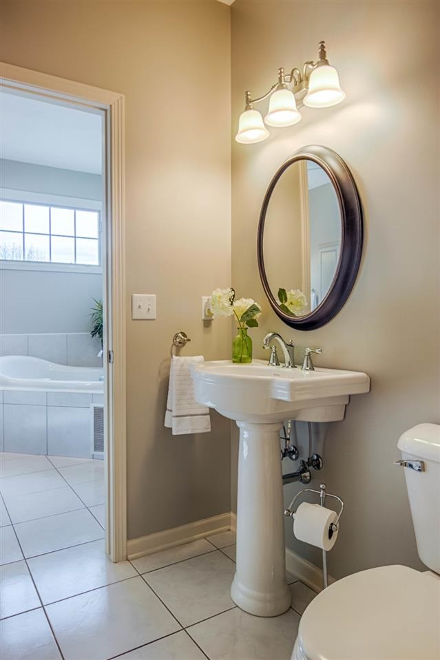 12210 Bellingham Road Caledonia, IL 61011 - Photo 16 of 24 a bathroom with a toilet a sink and a mirror