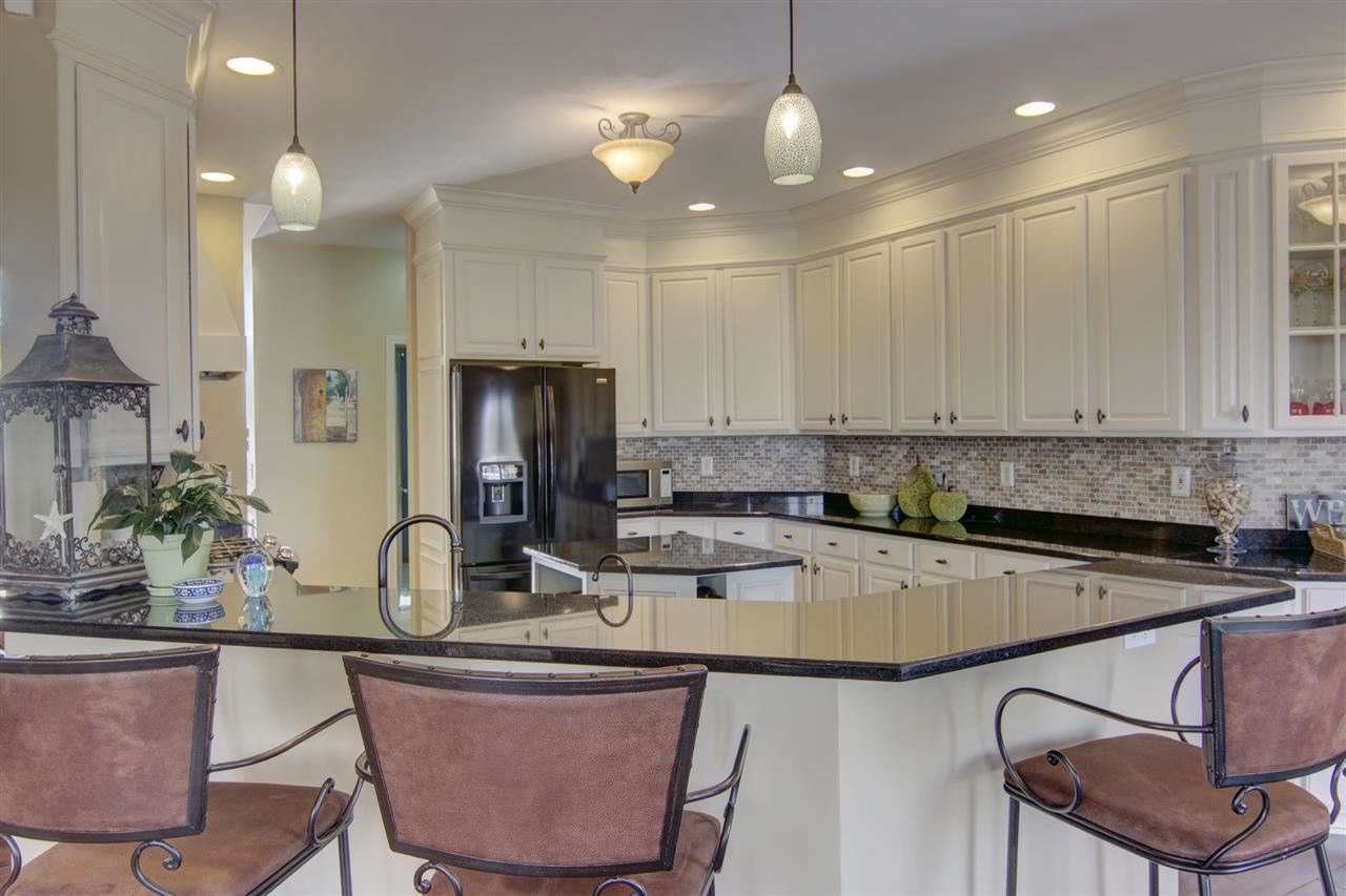 12210 Bellingham Road Caledonia, IL 61011 - Photo 6 of 24 a kitchen with a table chairs stove and microwave
