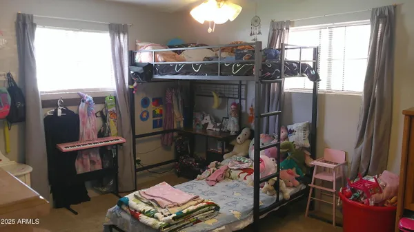a view of a hallway with a chair and potted plant on a table