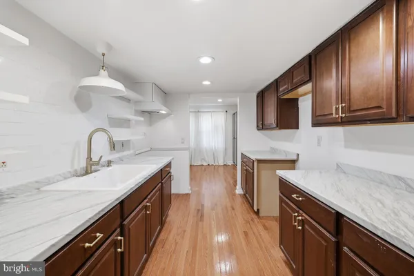 a kitchen with granite countertop a sink wooden cabinets and stainless steel appliances