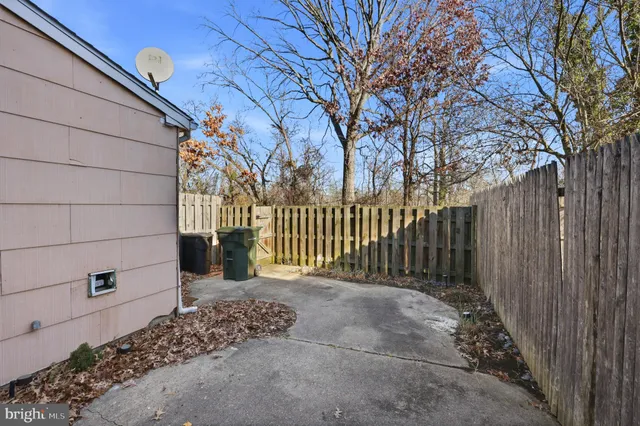 a view of a house with a small yard and wooden fence
