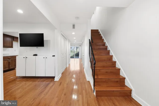 a view of a livingroom with wooden floor and staircase