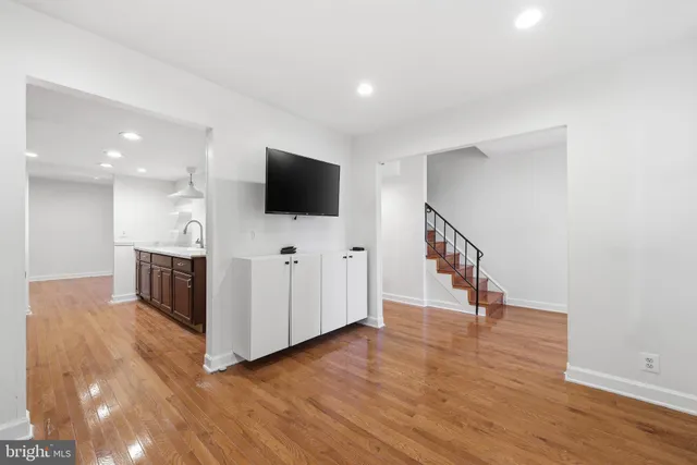 a view of a livingroom with wooden floor and a flat screen tv