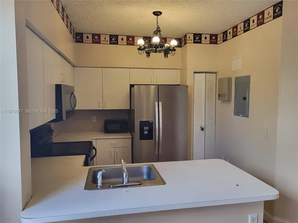 a kitchen with a refrigerator and a sink