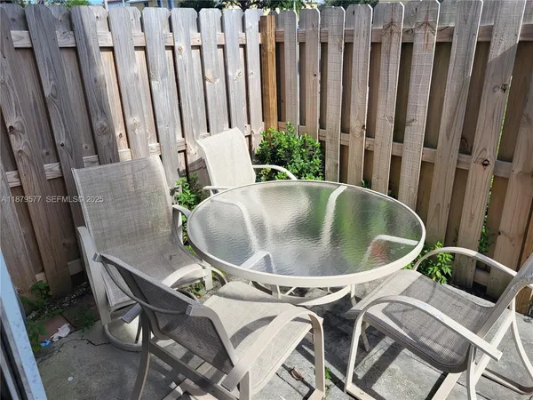 a view of balcony with chairs and wooden fence