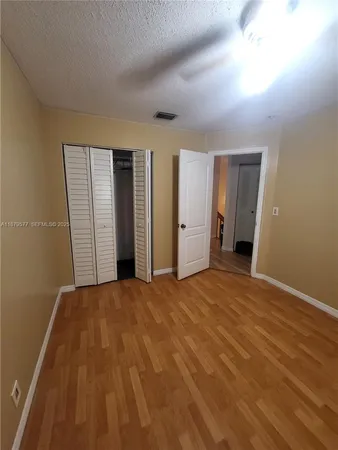 a view of empty room with wooden floor