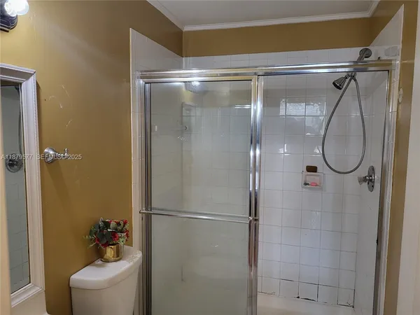 a bathroom with a glass shower door and mirror