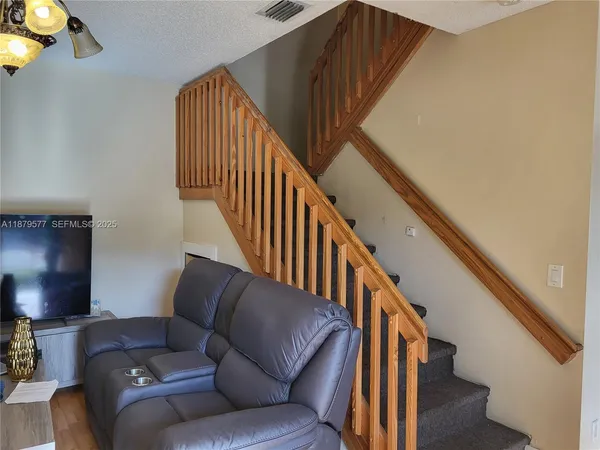 a living room with stairs and a couch
