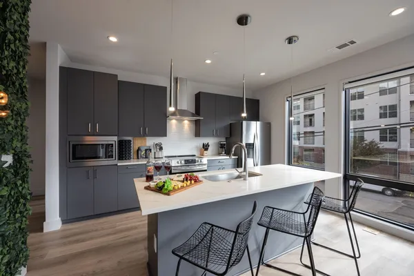 a kitchen with stainless steel appliances white cabinets and a refrigerator
