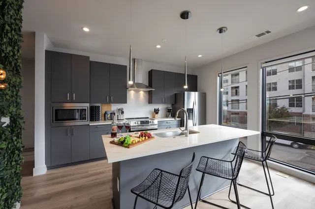 a kitchen with stainless steel appliances white cabinets and a refrigerator