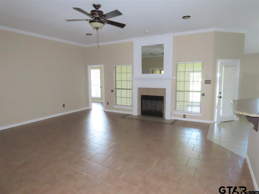 21206 Altuda Lane Flint, TX 75762 - Photo 3 of 13 an empty room with windows fireplace and a chandelier fan