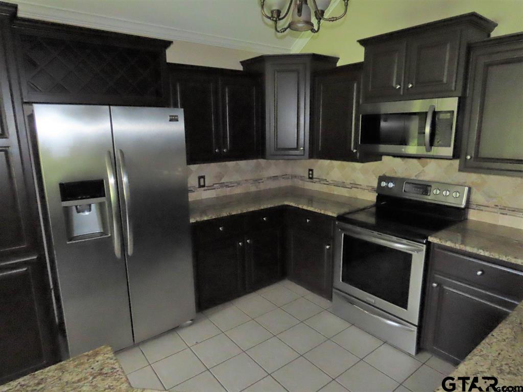 21206 Altuda Lane Flint, TX 75762 - Photo 6 of 13 a kitchen with stainless steel appliances kitchen island granite countertop a refrigerator and a sink