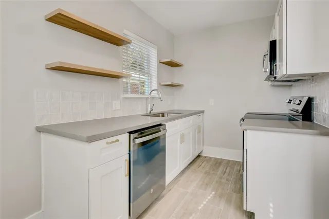 a kitchen with a sink cabinets and appliances