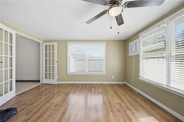 a view of an empty room with wooden floor and a window