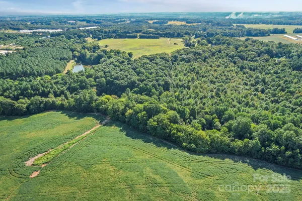 an aerial view of a houses with a yard and lake view