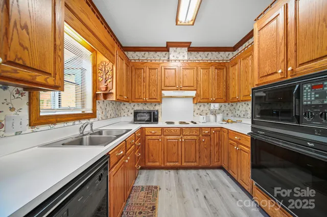 a kitchen with stainless steel appliances granite countertop a sink a stove and cabinets
